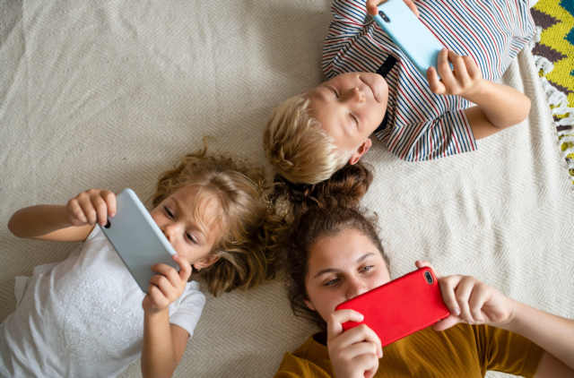 Kids lying on the floor and playing games on their phones Trauma behandeln: Lebensgeschichte wieder als sinnvoll, übereinstimmend und als Ganzes erlebt wird.